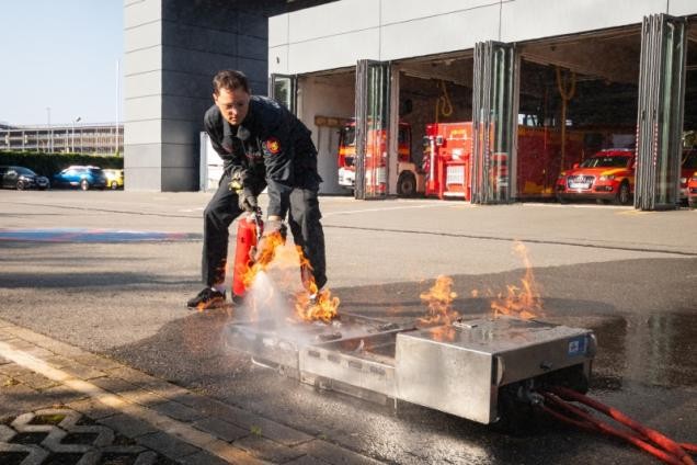 Feuerwehrmann löscht ein Feuer mit einem Feuerlöscher