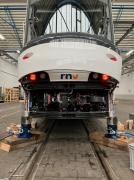 Straßenbahn mit Hydraulikstempeln angehoben Mit Hydraulikstempeln und Unterbauholz aufgebockter Kopf der Straßenbahn.