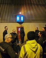 Ein Feuerwehrangehöriger steht an der aktivierten Notrufnische im Tunnel und hört Erläuterungen zum Handlingh zu